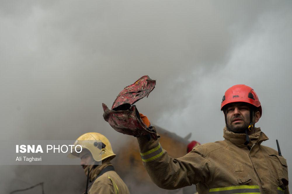 عکس/بیرون کشیدن کلاه یکی از آتشنشانان از زیر آوار پلاسکو