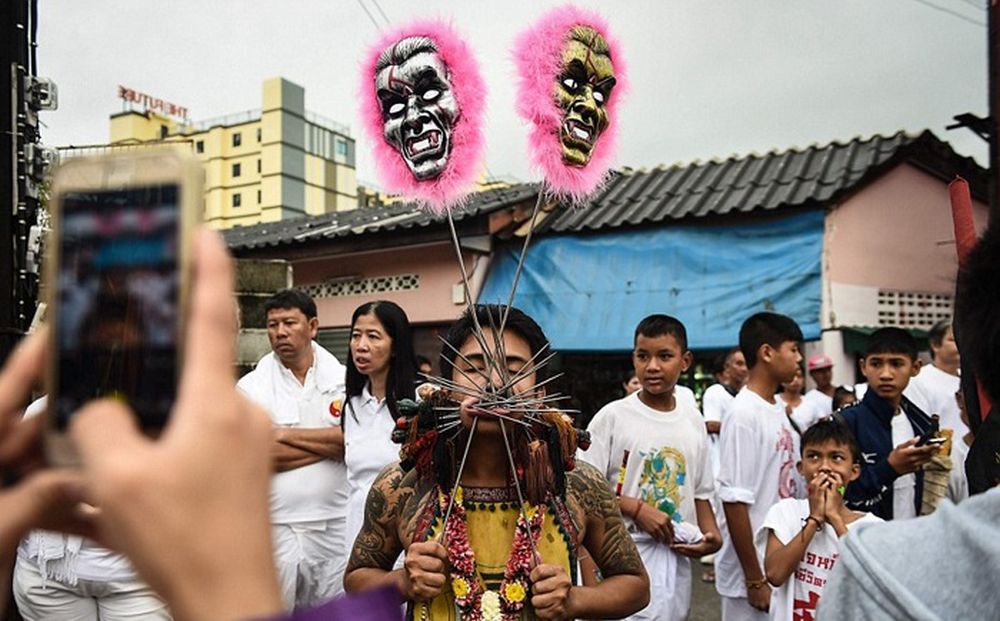 تصاویر : از سوراخ کردن بدن تا راه رفتن بر روی آتش در جشنواره گیاه‌خواران تایلند