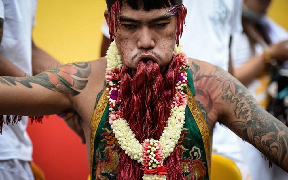 تصاویر : از سوراخ کردن بدن تا راه رفتن بر روی آتش در جشنواره گیاه‌خواران تایلند